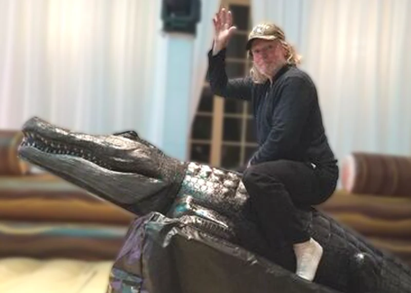 Guest riding Chomps the mechanical alligator ride rental at a Florida party