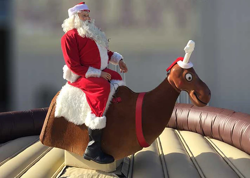 Santa riding the mechanical reindeer rental at a Florida holiday party