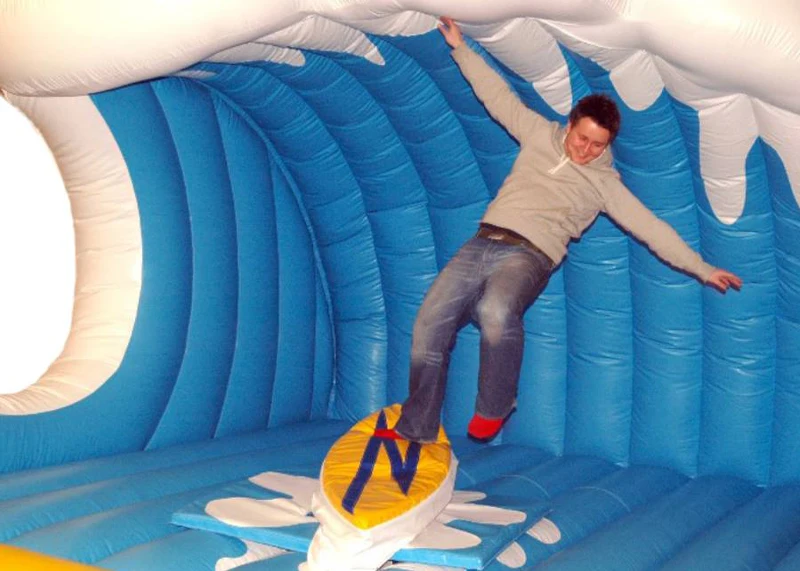 Rider balancing on the mechanical surfboard rental over an inflatable cushion